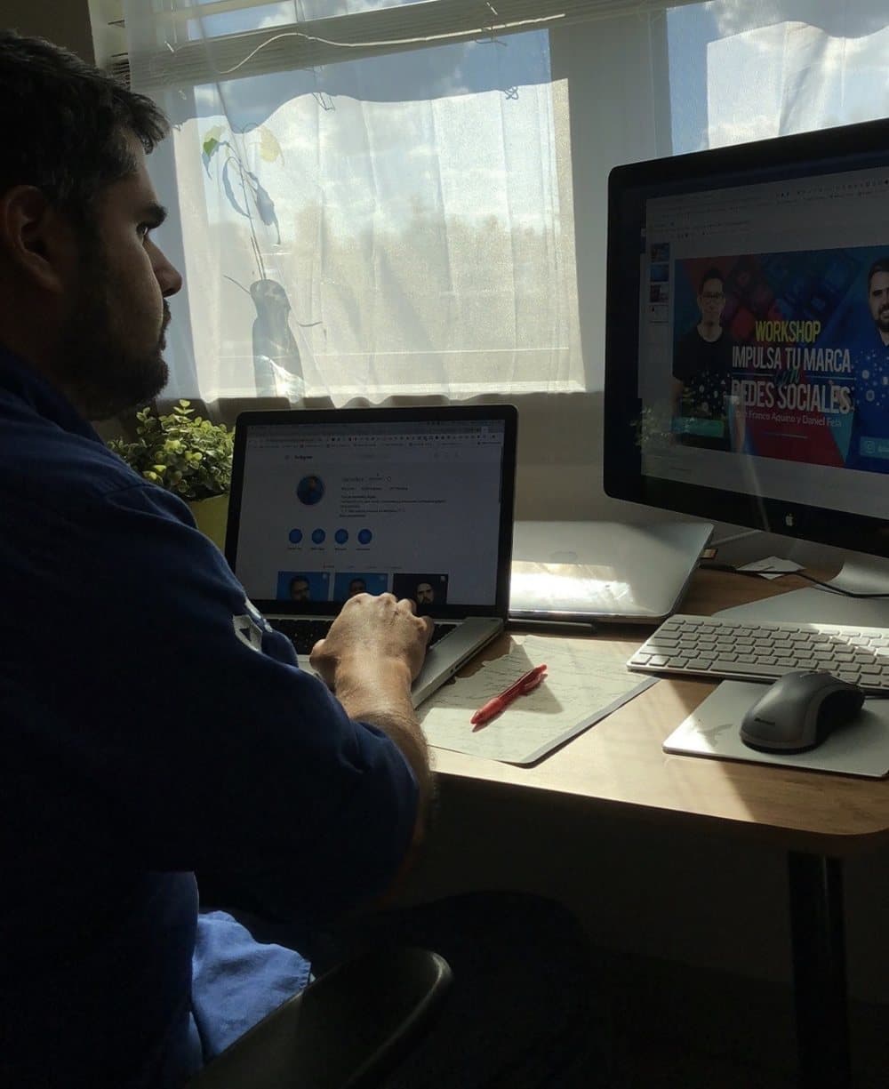 Daniel Fela trabajando en su escritorio, con un workshop de marca en redes sociales en la pantalla